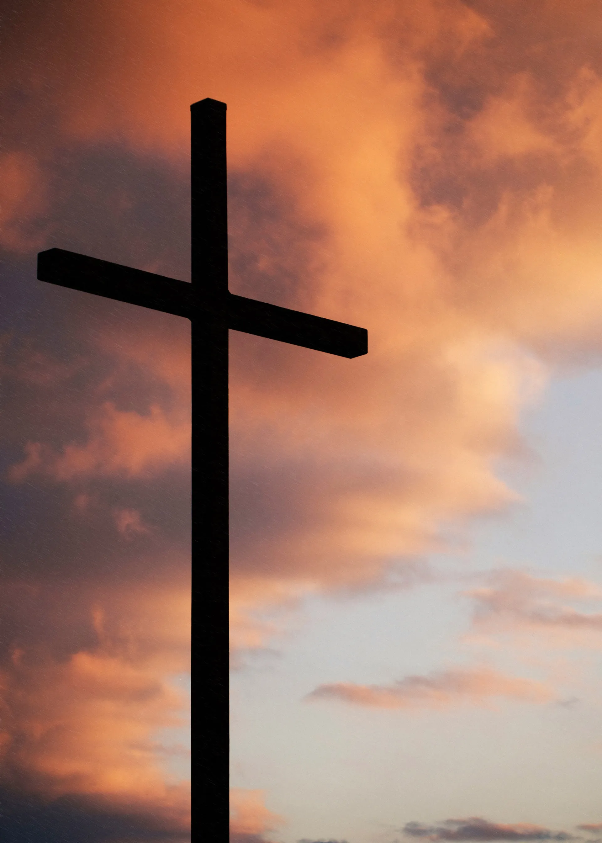 cross silhouette against a dramatic sunset sky